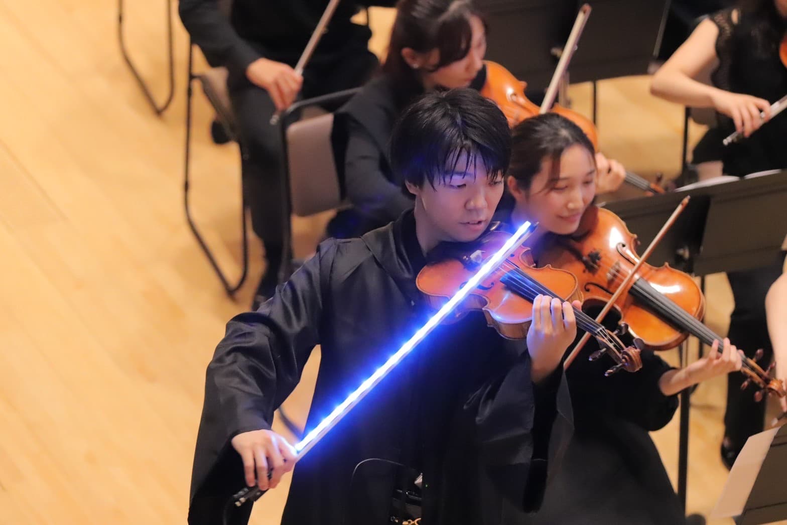 演奏会でライトセーバー型の弓を手に演奏する佐久間基就